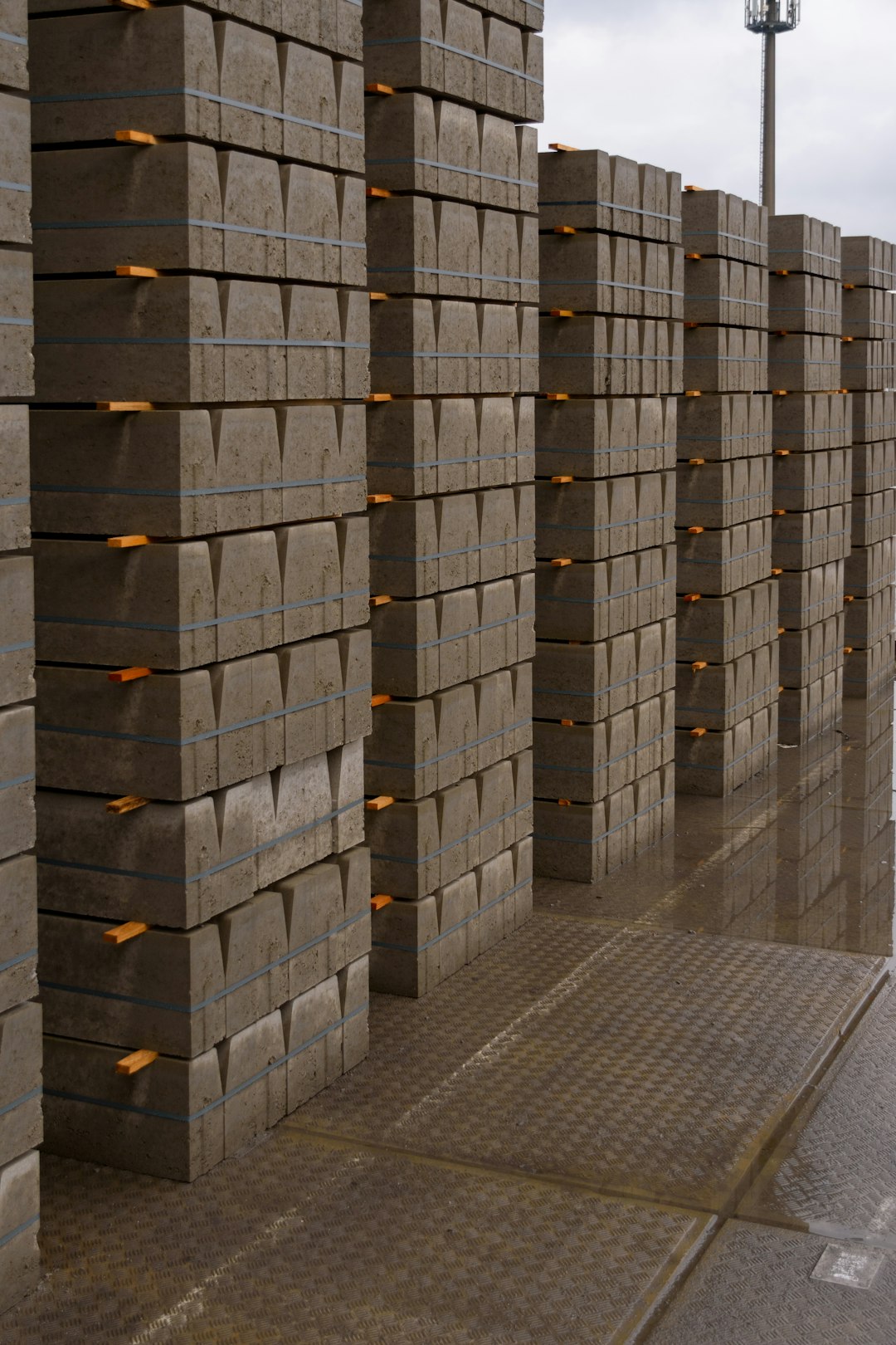 stacks-of-concrete-curbs-on-a-wet-surface-dzmjnzcdr4g