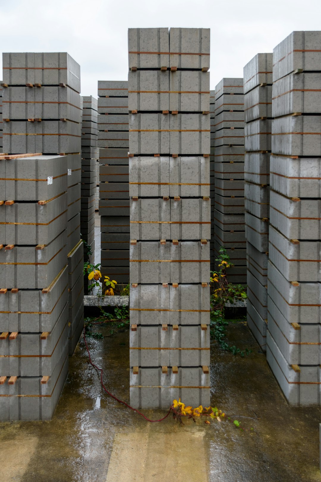 stacks-of-concrete-paving-stones-on-a-wet-surface-otarejqsbms